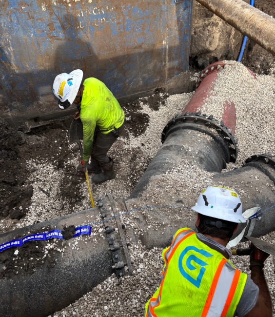 Two men working in trench box